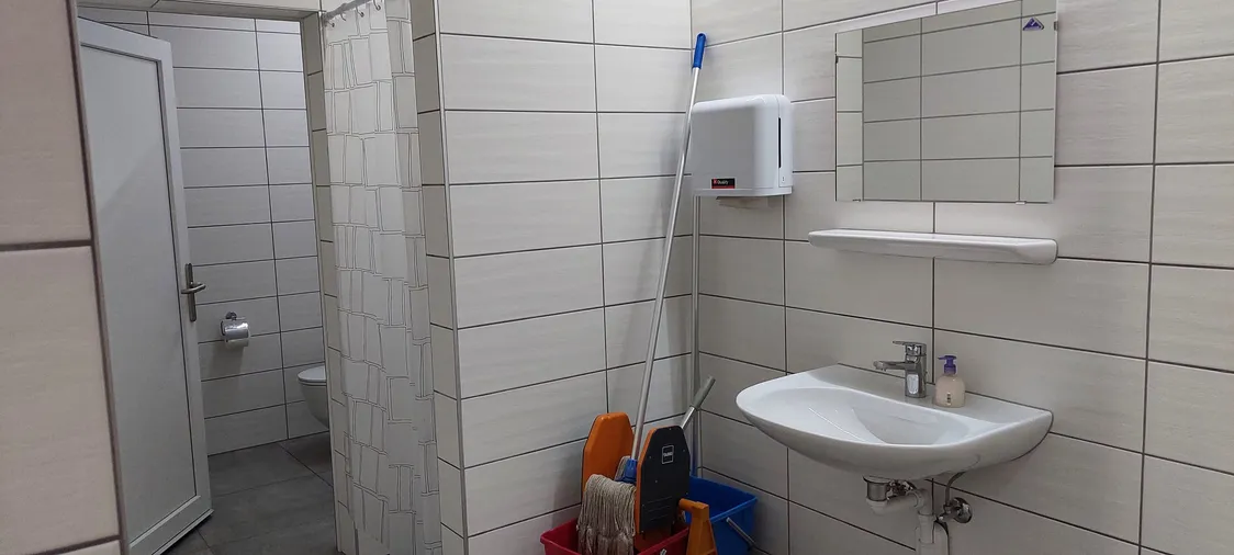 Les sanitaires entièrement carrelés : lavabo, miroir, distributeur et WC séparés